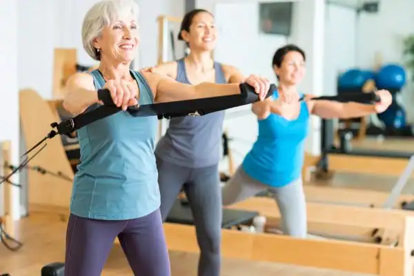 Toning Arms After 60: Empowering Womens Fitness Through Effective Weight Training 2 older woman doing weight training Felixstowe and resistance in the gym to tone upper arms