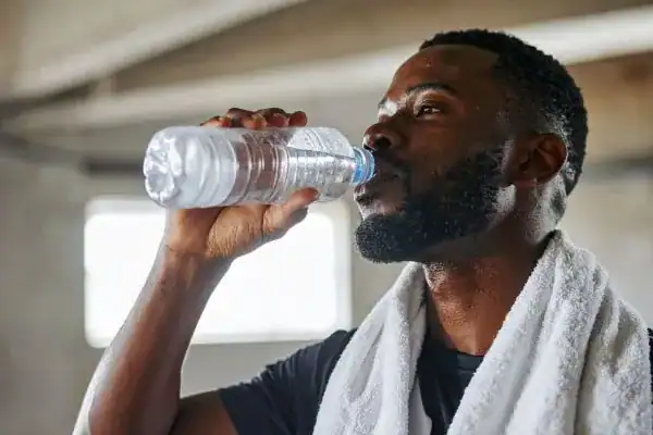 Image of man drinking water to improve hydration Felixstowe after work out.